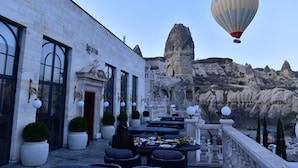 A restaurant with outdoor seating overlooking a rocky landscape. - Sacred Mansion (Nevsehir)