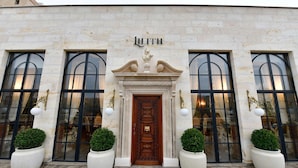 A building with a large wooden door, the name "LILITH" above it, and large windows with black frames. - Sacred Mansion (Nevsehir)
