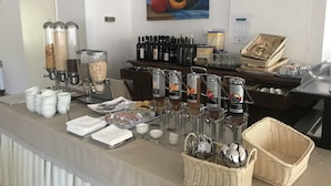 Un'area buffet con diversi distributori di cibo e bevande, un quadro e un frigorifero.