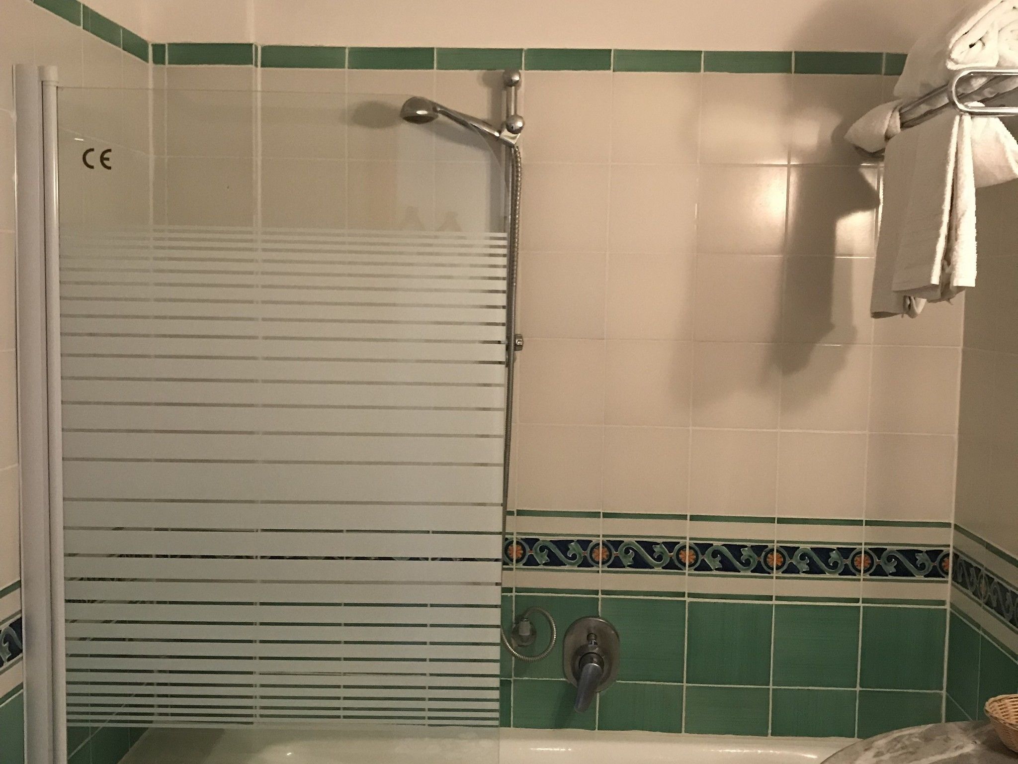 A bathroom with a shower, a bathtub, and a towel rack.