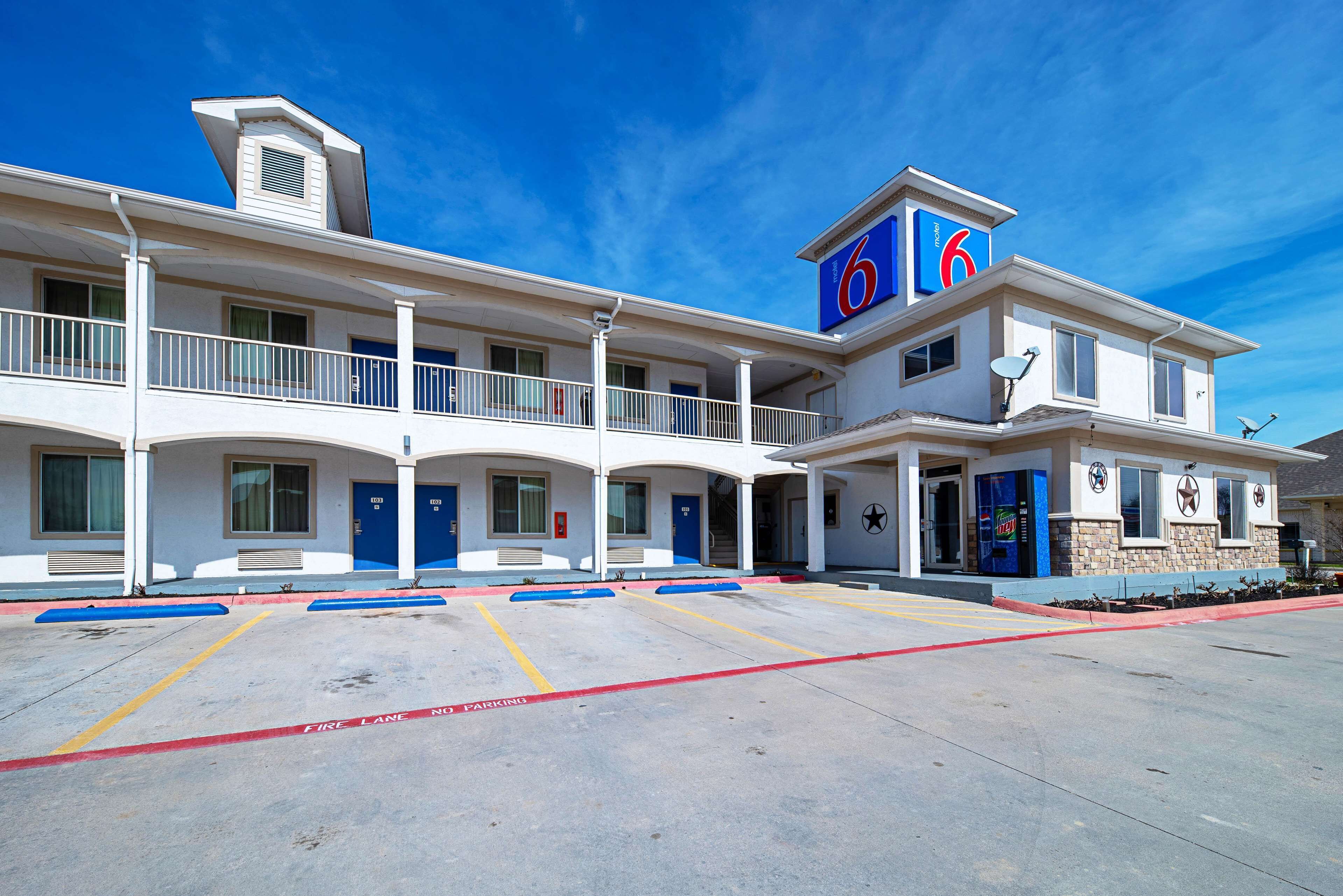 A motel with a '6' sign, multiple balconies, and a fire lane.