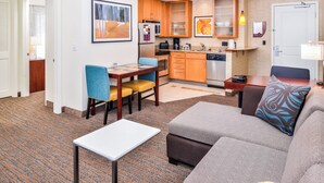A compact living space with a kitchenette, a dining area, and a seating area with a sofa and ottoman. - Residence Inn Marriott Waynesboro (Waynesboro)