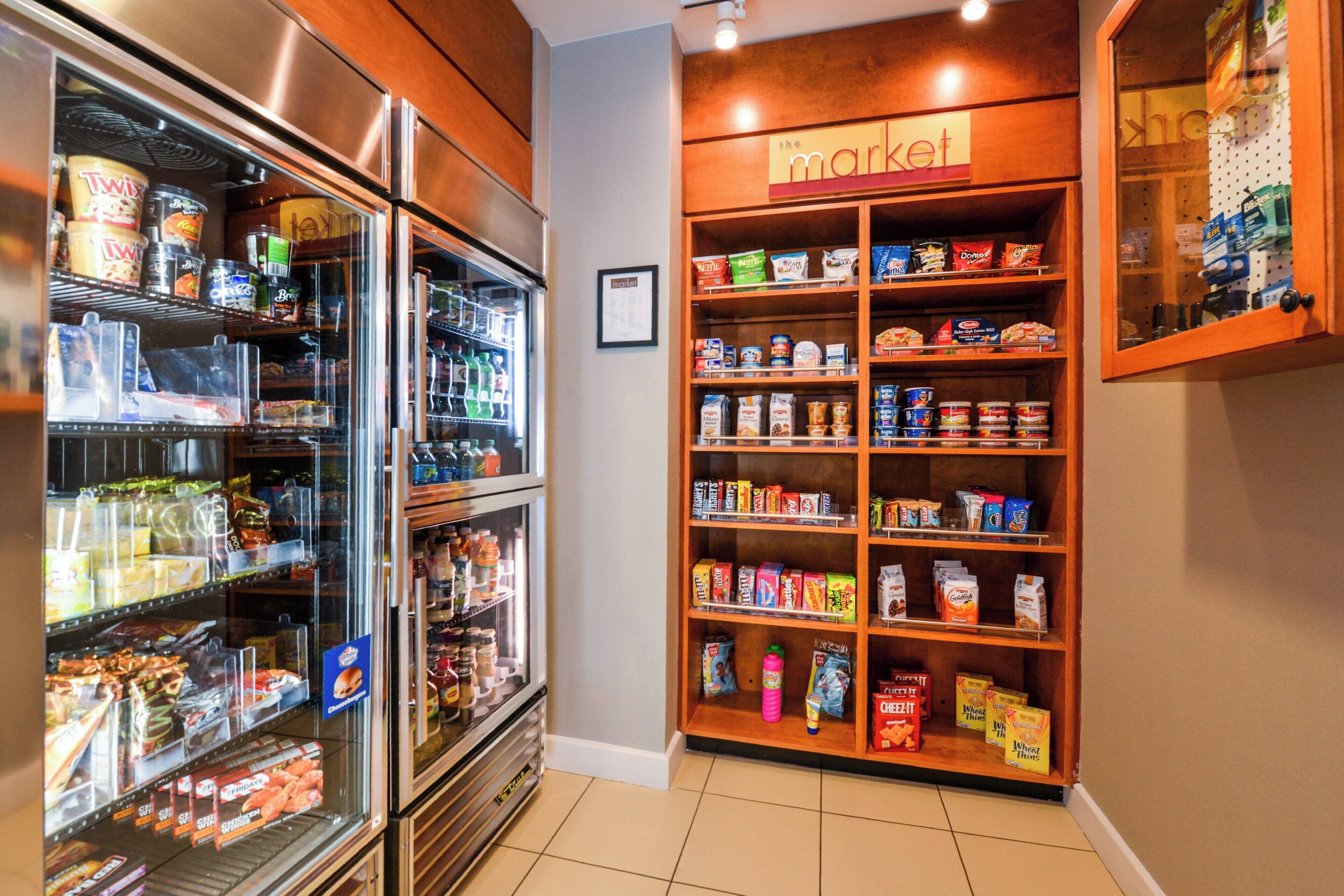 A grocery store with refrigerated sections and shelves stocked with various food items.