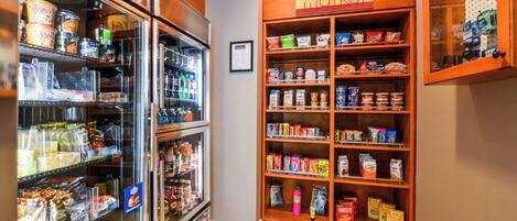 A grocery store with refrigerated sections and shelves stocked with various food items.