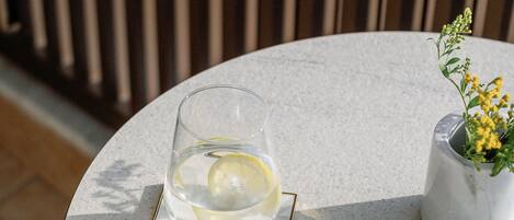 Una mesa redonda con un vaso de agua y una pequeña planta en maceta.