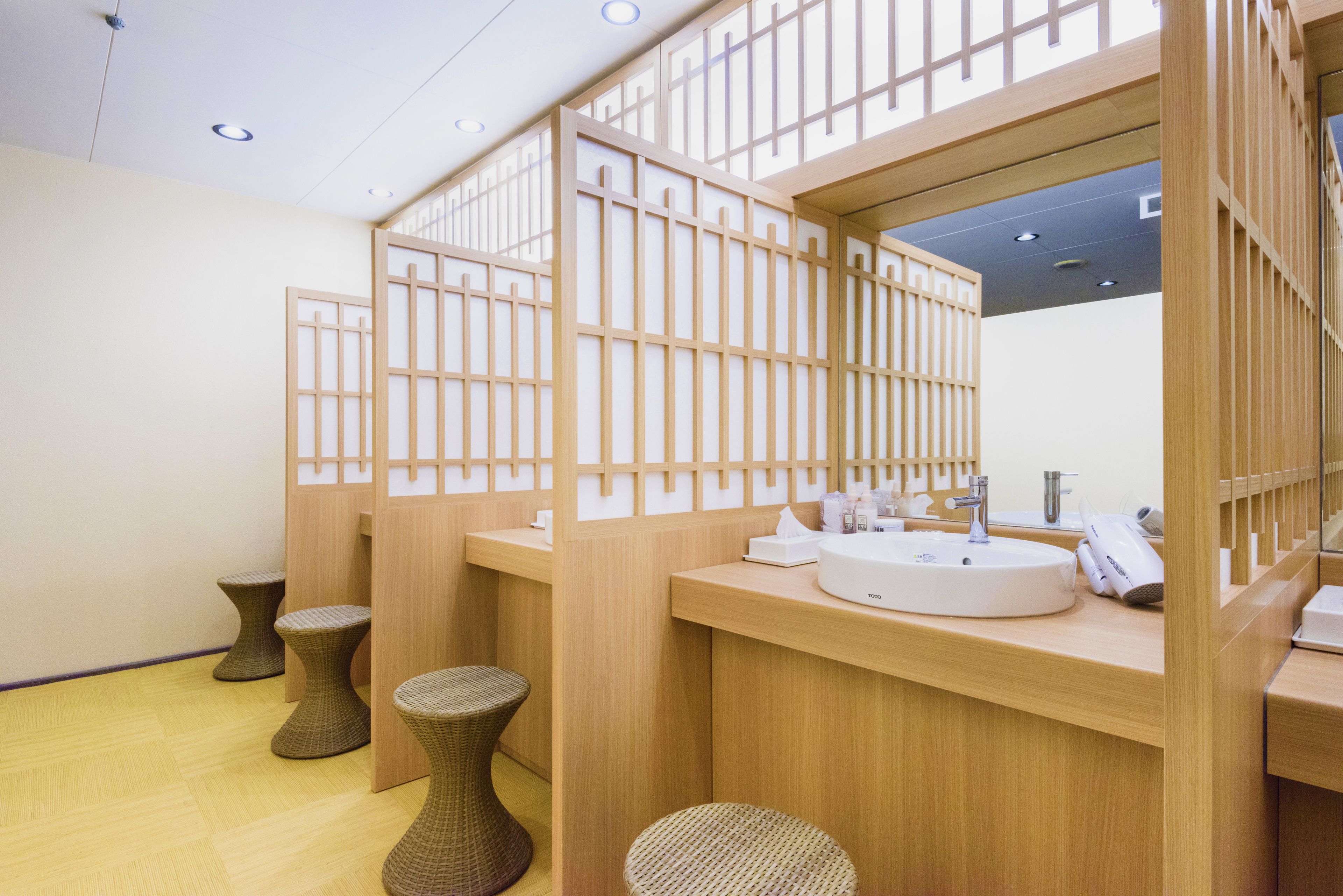 Un baño moderno con separadores de madera, un lavabo y un espejo.