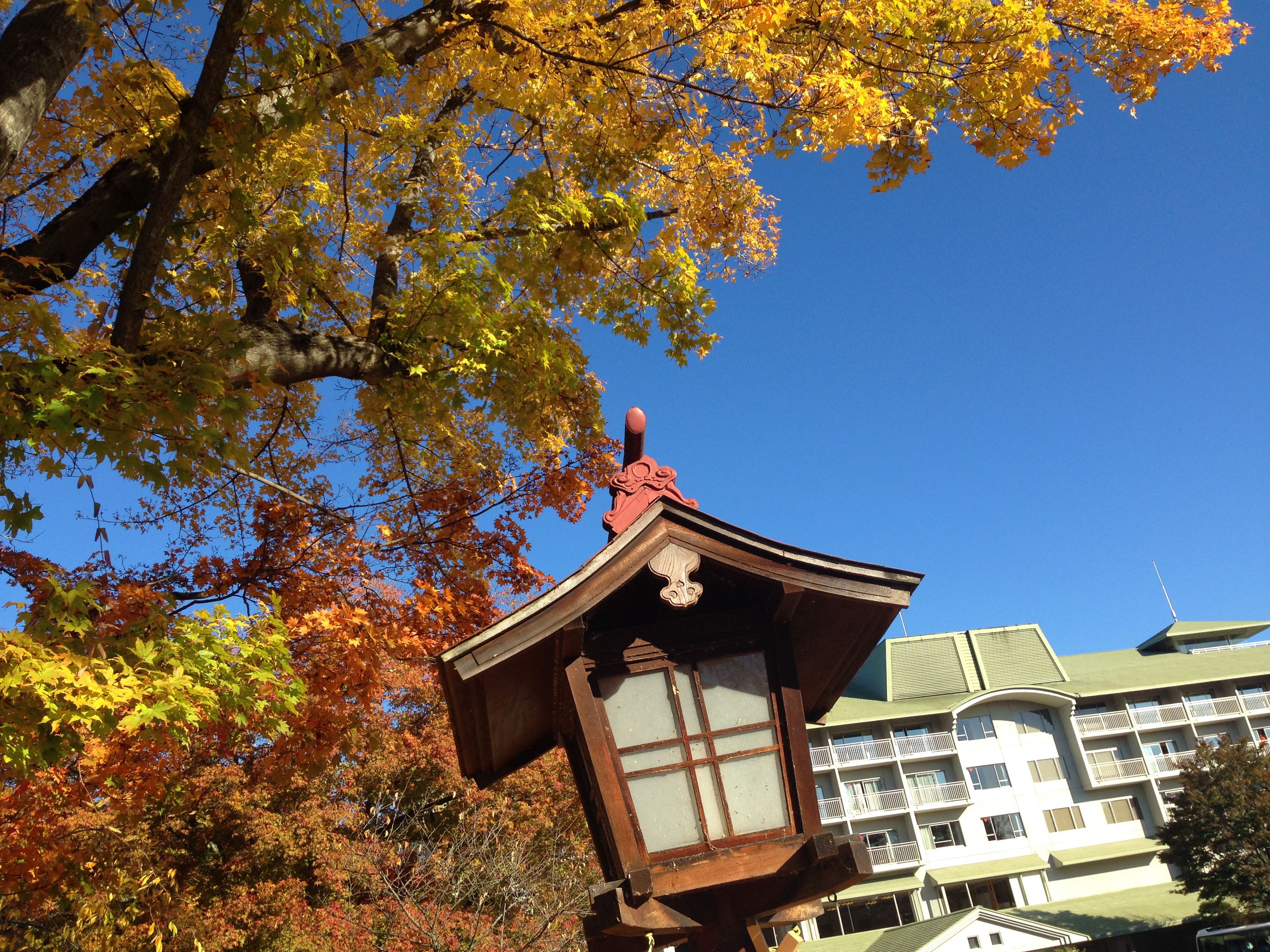 A traditional Japanese building with a distinct roof and a wooden structure in front.