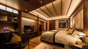 Une chambre d’hôtel comprenant un lit, un bureau, une télévision et un coin salon.