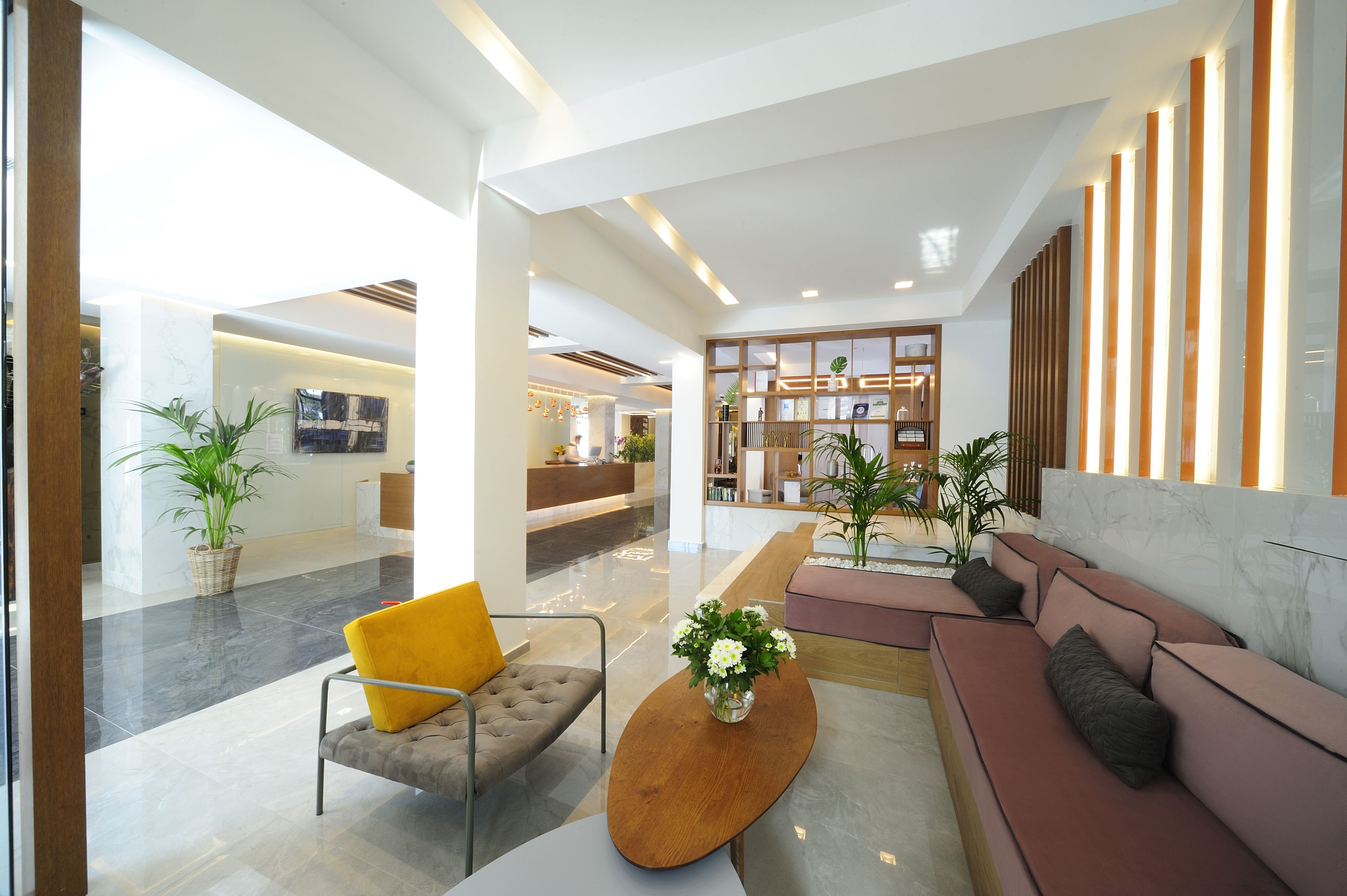 Eine moderne Lobby mit einer Rezeption, einer Sitzecke und einer Rezeption mit Holzvertäfelung.