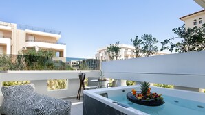 A rooftop terrace with a hot tub, seating area, and a table with a fruit bowl. - Atrium Ambiance Hotel (Rethymno)