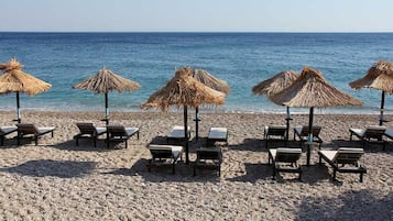 Vlak bij het strand, ligstoelen aan het strand, parasols, een strandbar