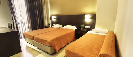 A hotel room with two beds, a desk, a nightstand, and a large window with curtains.
