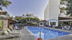 Zona de piscina amb gandules, un flotador i mobiliari exterior.