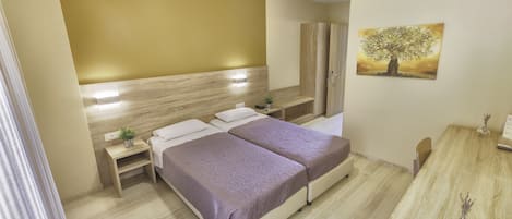 Habitación de hotel con dos camas, cabecero de madera, mesita de noche con una planta, un cuadro de un árbol y un escritorio de madera con un jarrón.