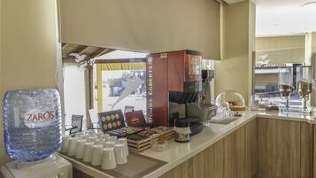 Un espace dédié au café, équipé d’un distributeur d’eau, d’une machine à café et de différents types de tasses.