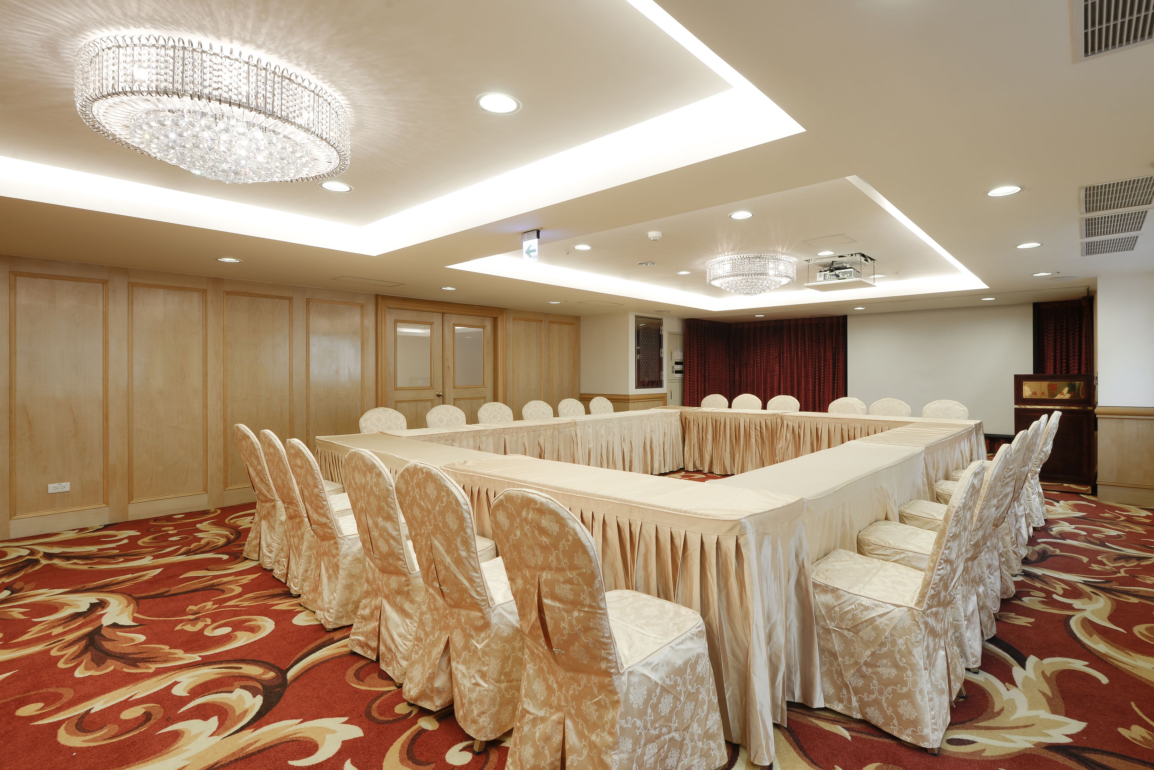 A conference room with a long table, chairs, and a chandelier.