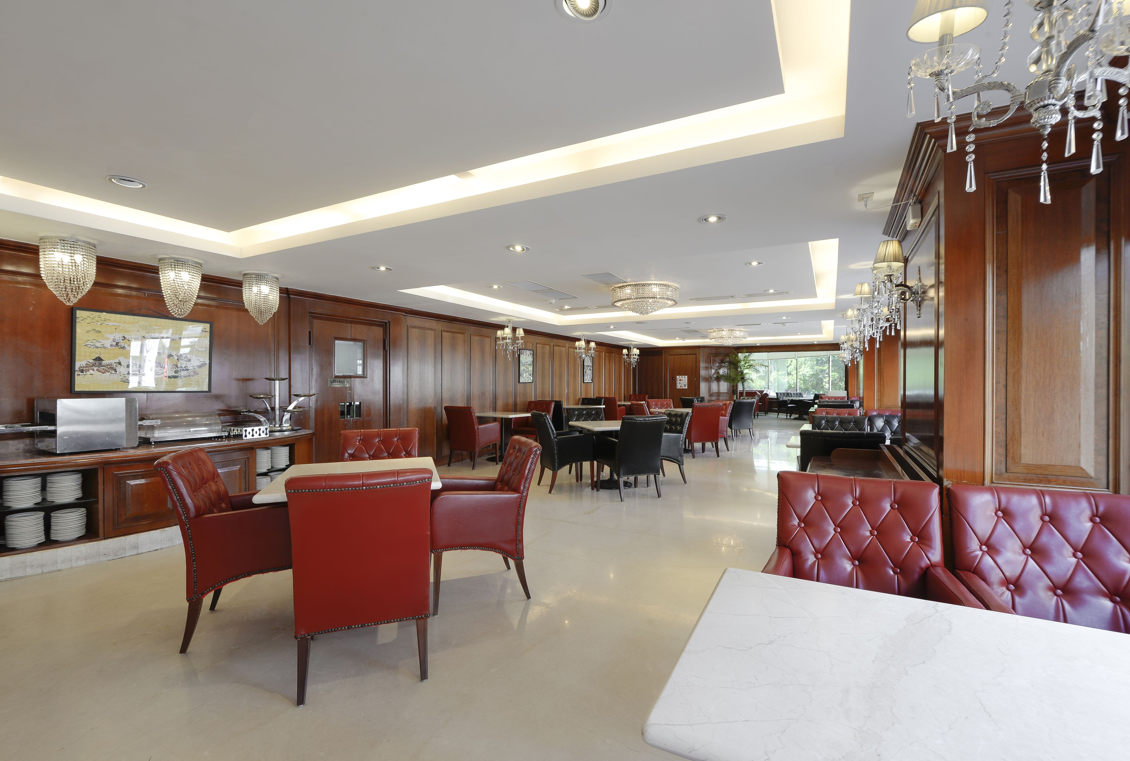 A spacious hotel lobby with leather seating, a bar area, and a large chandelier.