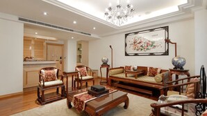 A spacious living room with a sofa set, chairs, a coffee table, and a chandelier. - Hotel Sunshine (Kaohsiung)
