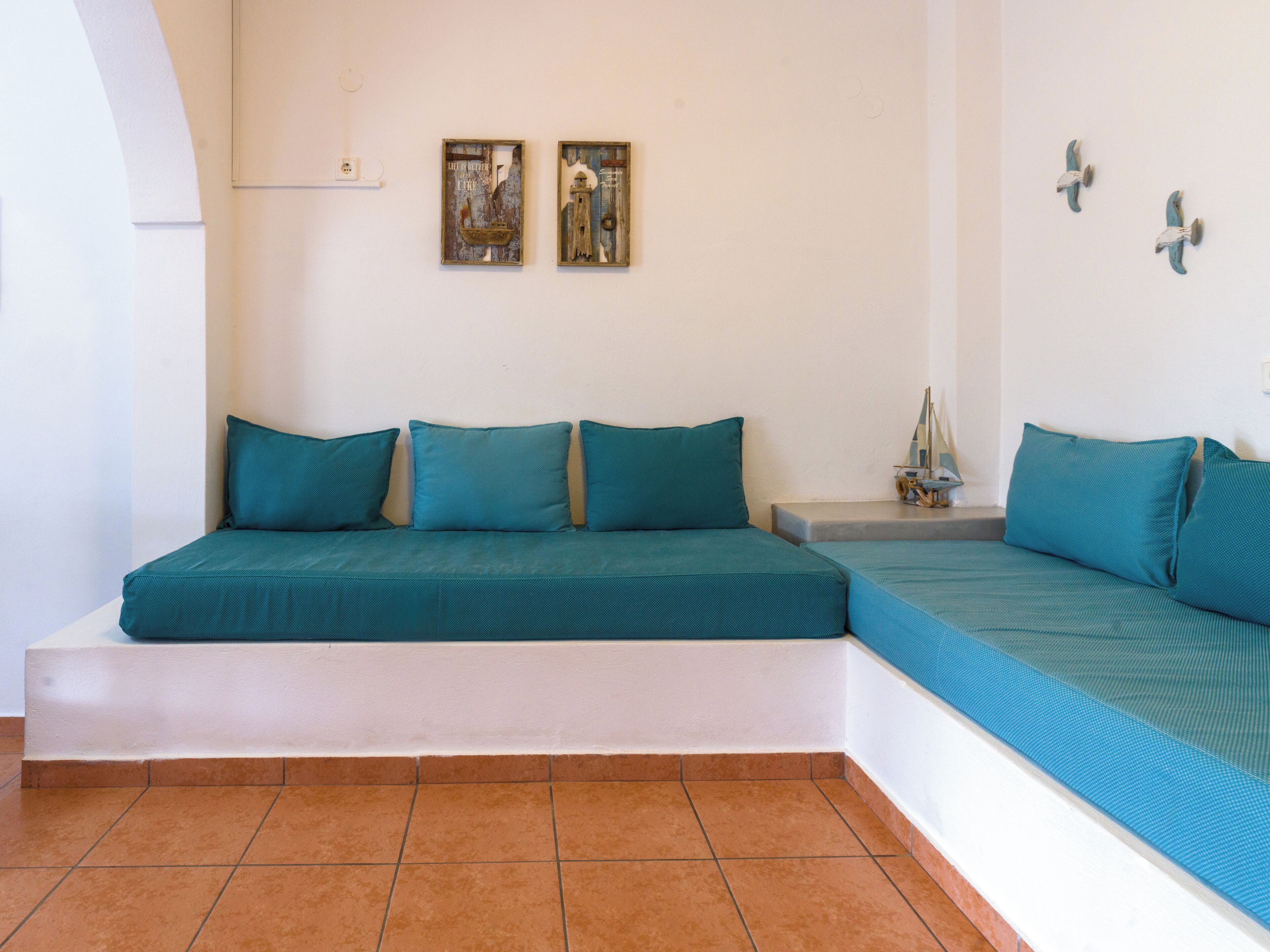 A room with a bed, a small table, and two wall-mounted artworks.