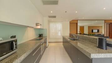 Una cocina moderna con encimeras de granito, electrodomésticos de acero inoxidable y una isla grande.