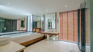 A modern bathroom with a large bathtub, two sinks, and a large mirror.