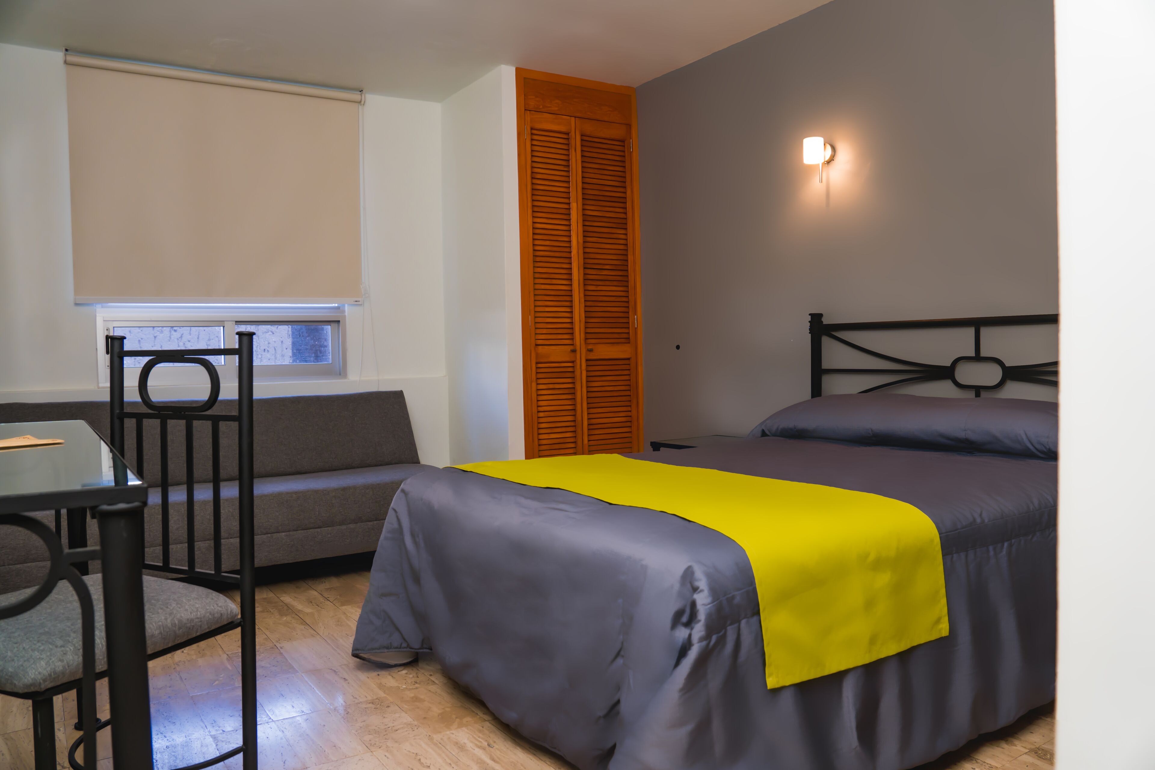 Ein Zimmer mit einem Bett, einem Schreibtisch und einem Fenster.