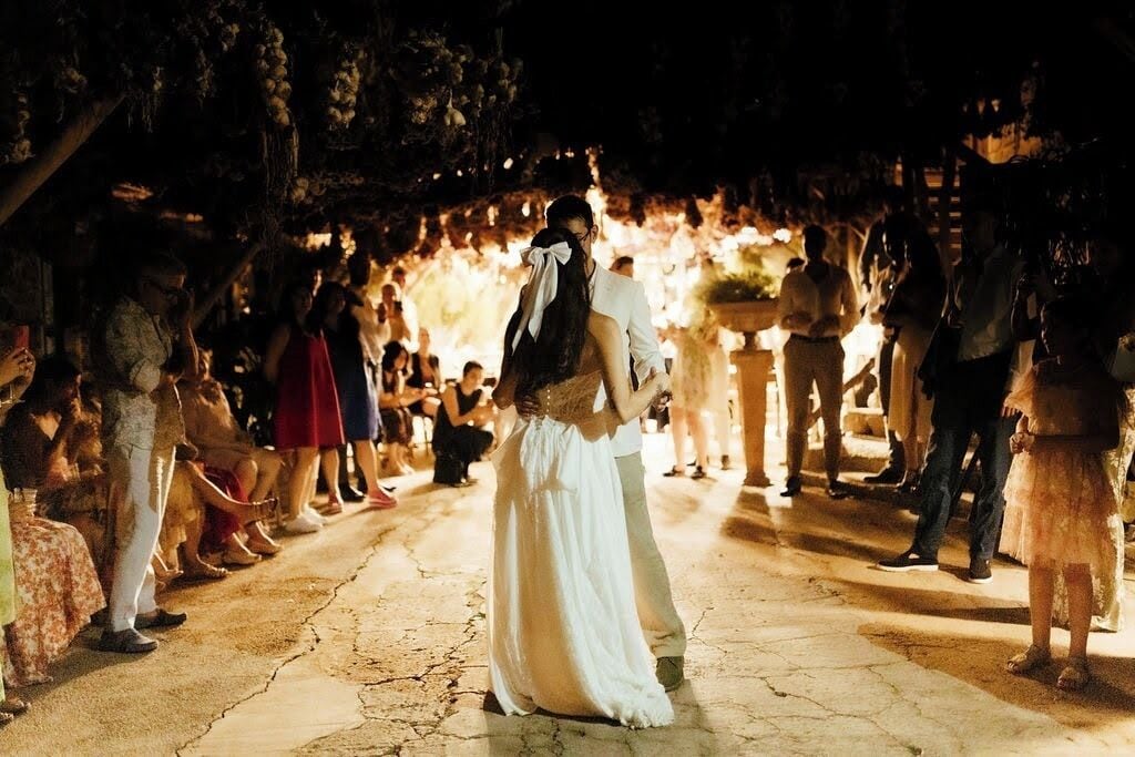 Une cérémonie de mariage où les invités sont assis de part et d’autre d’une allée centrale.