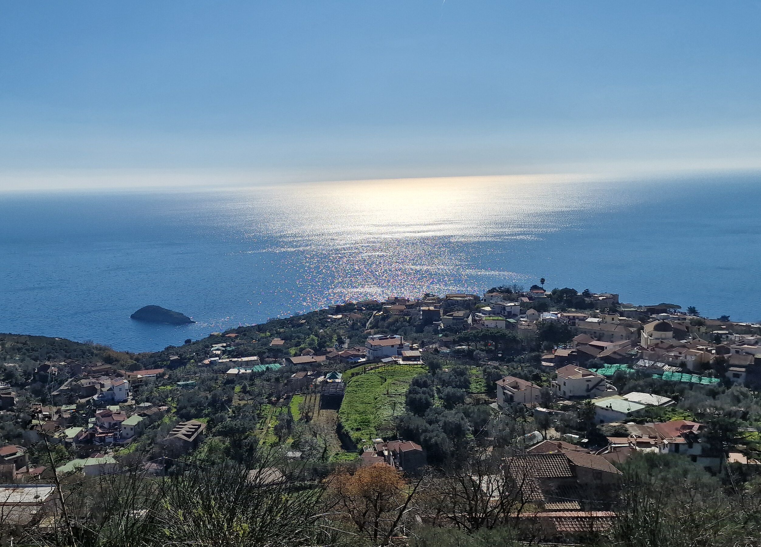 A coastal village with houses on a hillside overlooking the sea.