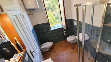 Un baño moderno con cabina de ducha de vidrio, inodoro y bidé.