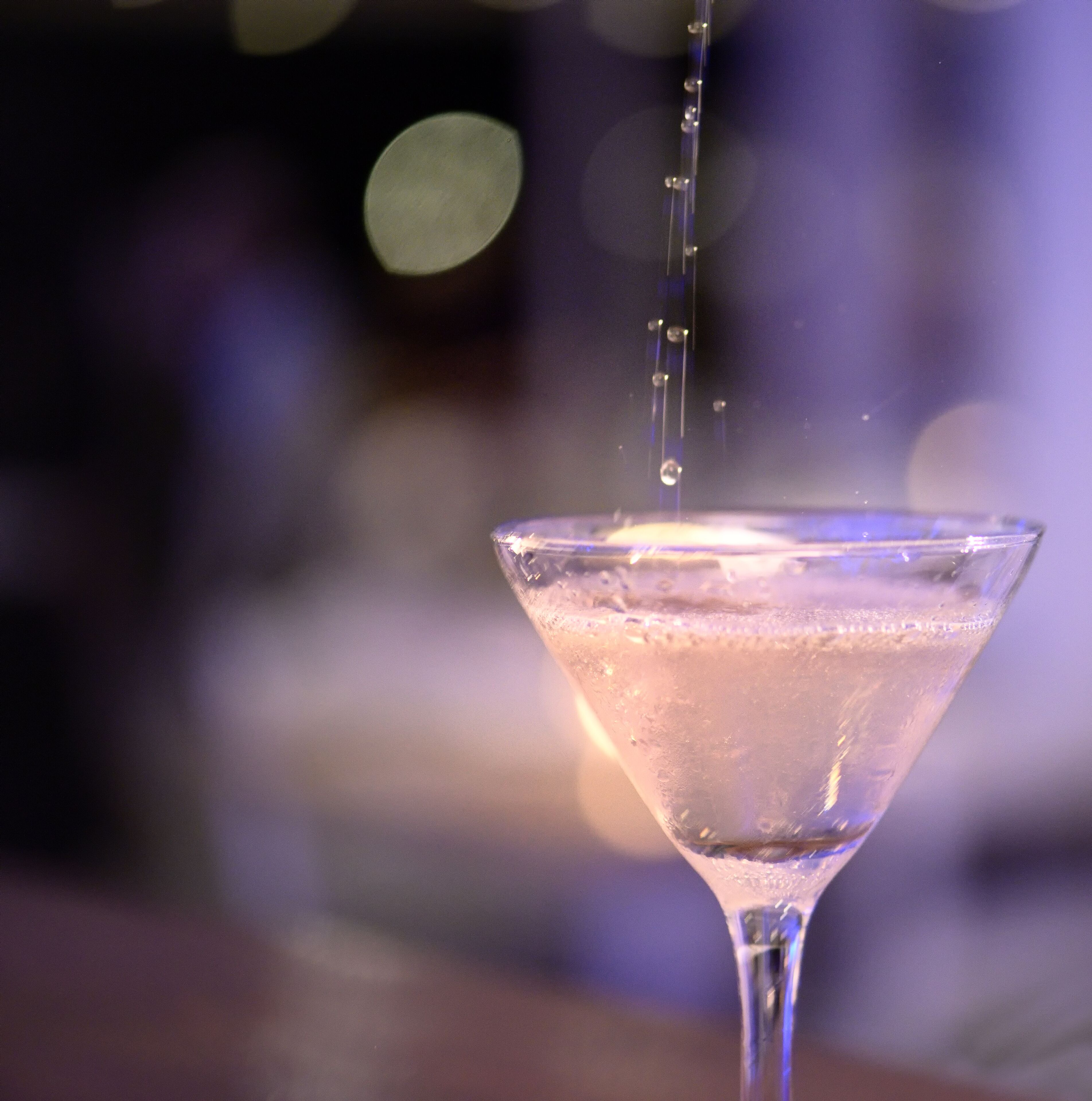 Se sirve una bebida transparente en una copa de martini, probablemente un cóctel.