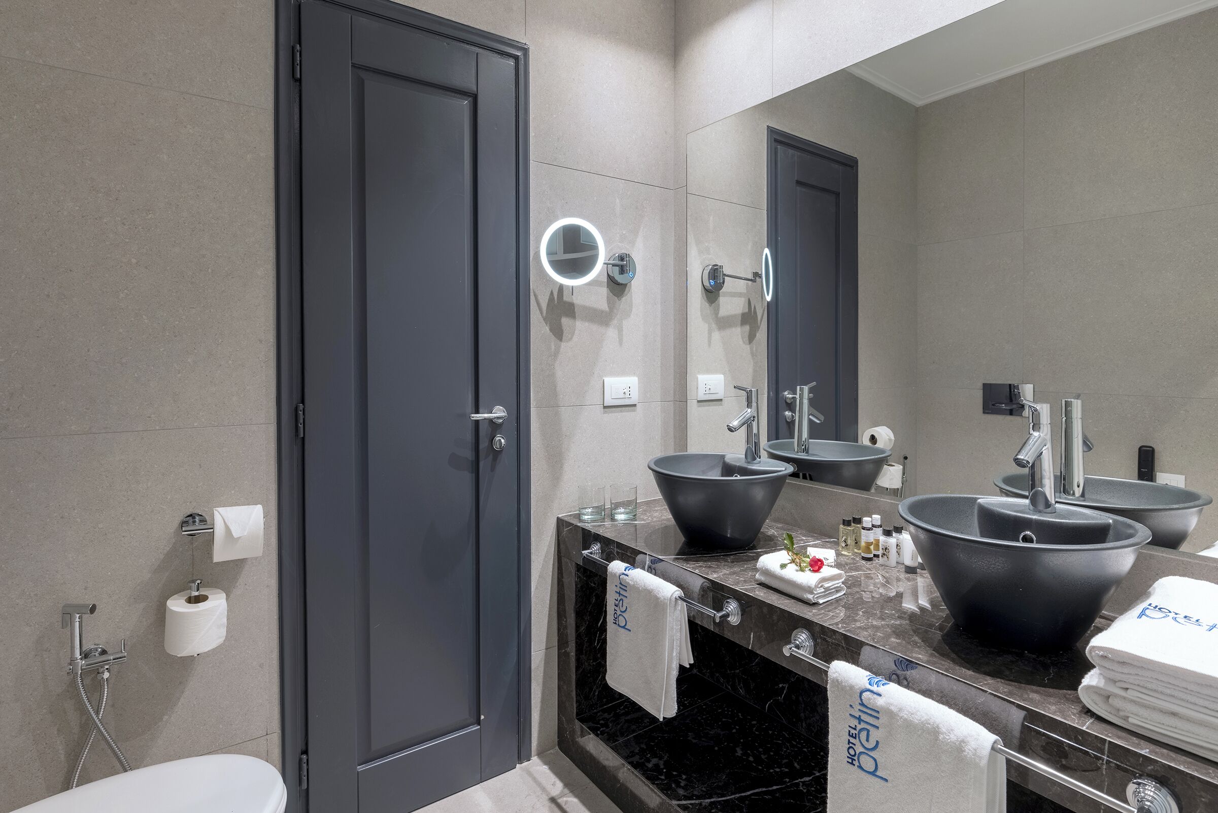 Un bagno moderno con uno specchio grande, due lavabi e un water.