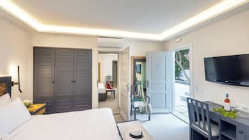 A modern hotel room with a bed, a desk with a chair, a TV, and a wardrobe.