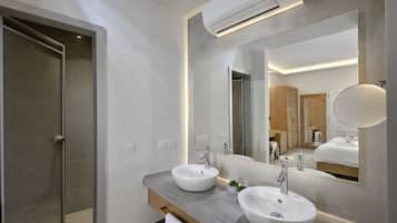 A modern bathroom with two sinks, a large mirror, and a wooden vanity.