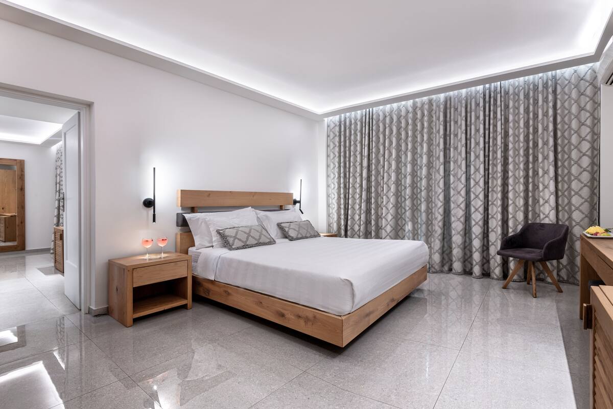 A modern bedroom with a wooden bed, bedside tables, and a chair.
