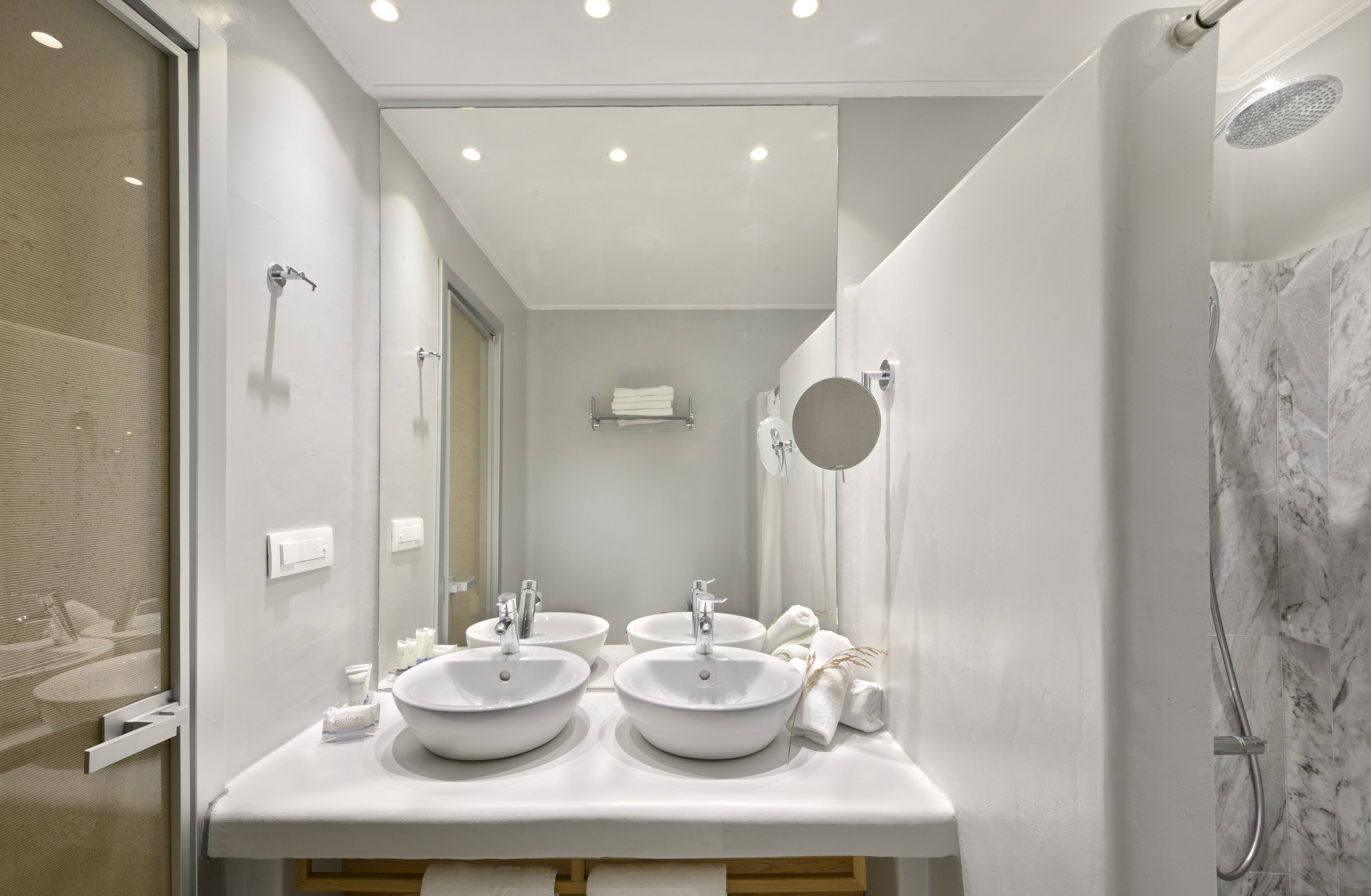 Een moderne badkamer met twee wastafels, een grote spiegel en een douchehoek.