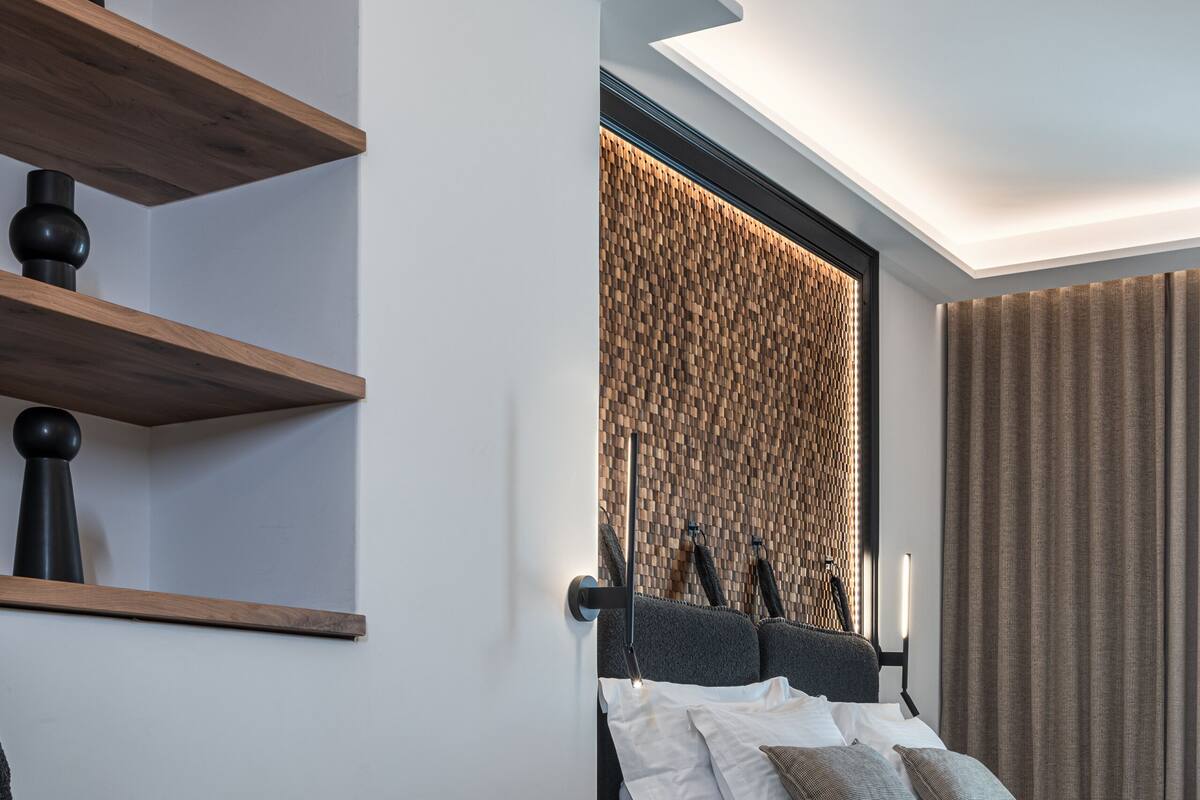 A modern hotel room with a neatly made bed, a dining table with a plate of food, and a coffee table.