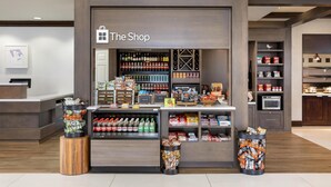 Un magasin dont les étagères sont remplies d’en-cas, de boissons et d’autres articles.