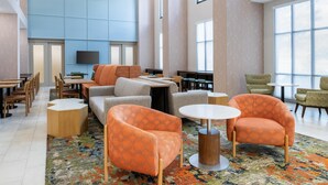 A spacious lounge area with multiple seating options, a flat-screen TV, and large windows providing natural light. - Hampton Inn & Suites Prescott Valley (Prescott Valley)