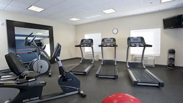 A hotel fitness center with treadmills, an elliptical, and a rowing machine.