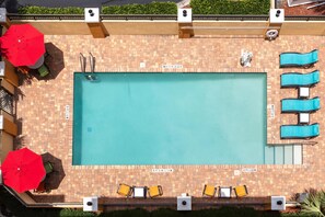 Una piscina al aire libre, sillones reclinables de piscina