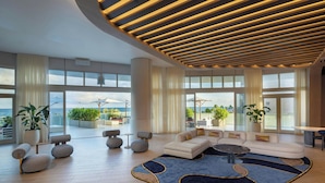 A spacious living area with a modern design, featuring a large sofa set, a coffee table, and a patterned rug. - W Fort Lauderdale (Fort Lauderdale)