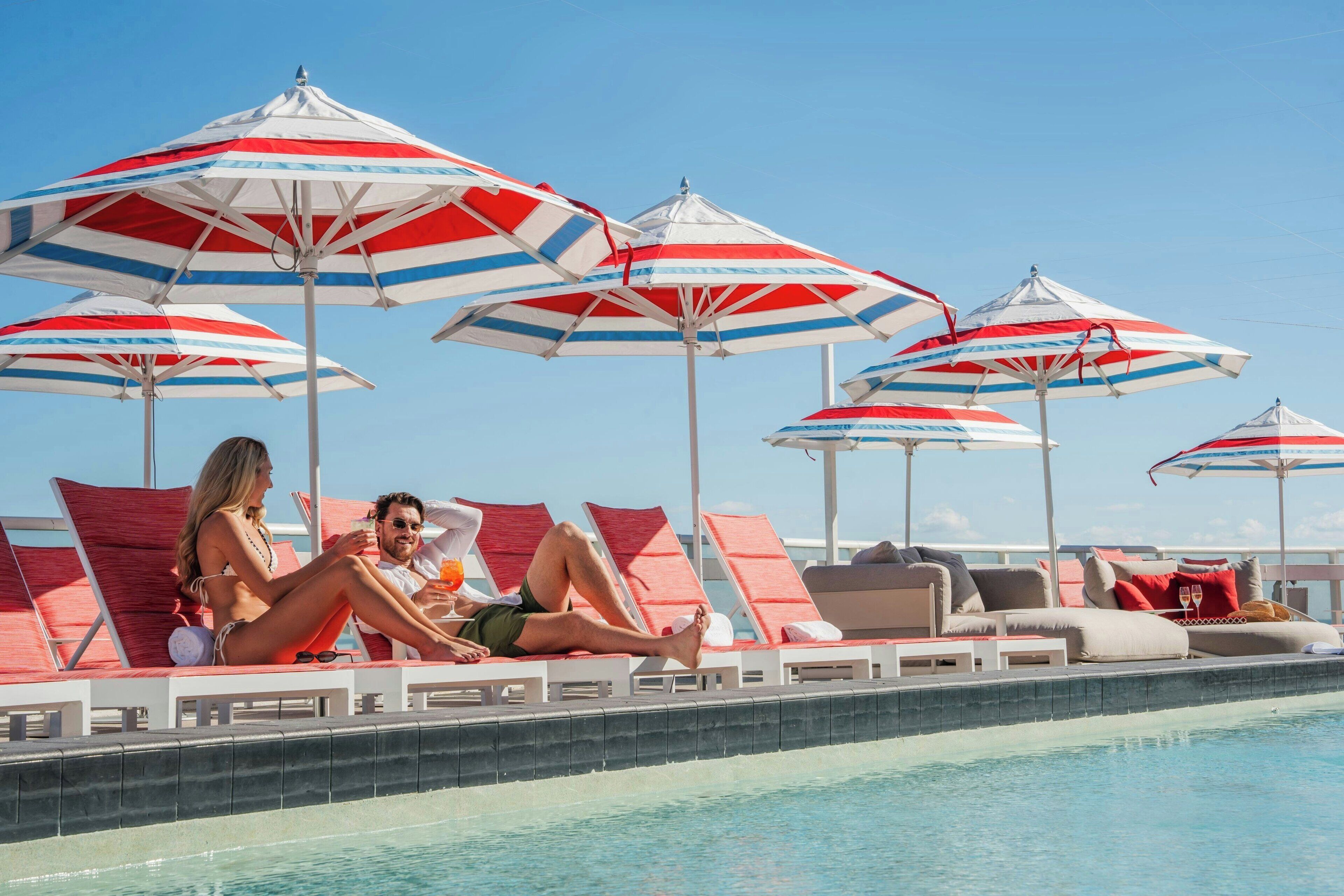 A poolside area with lounge chairs and umbrellas.