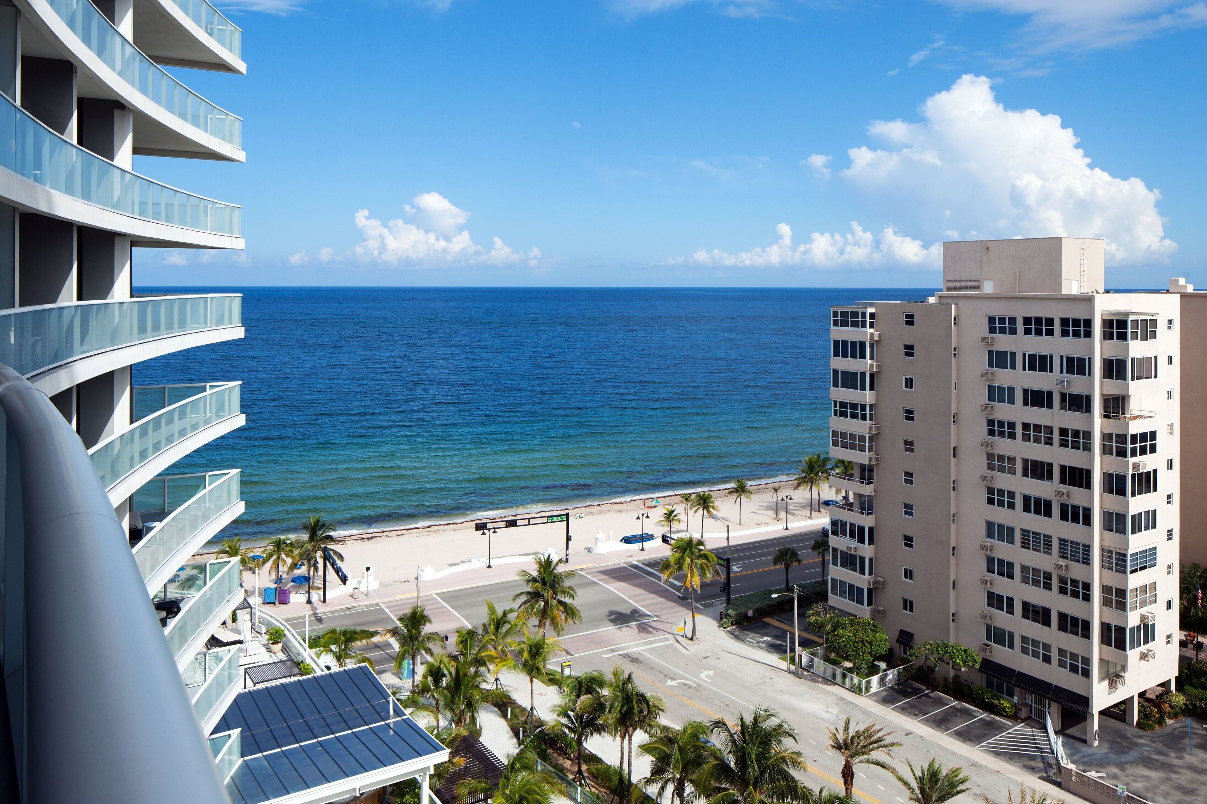 Un hotel moderno con balcones que dan a la playa y al océano.