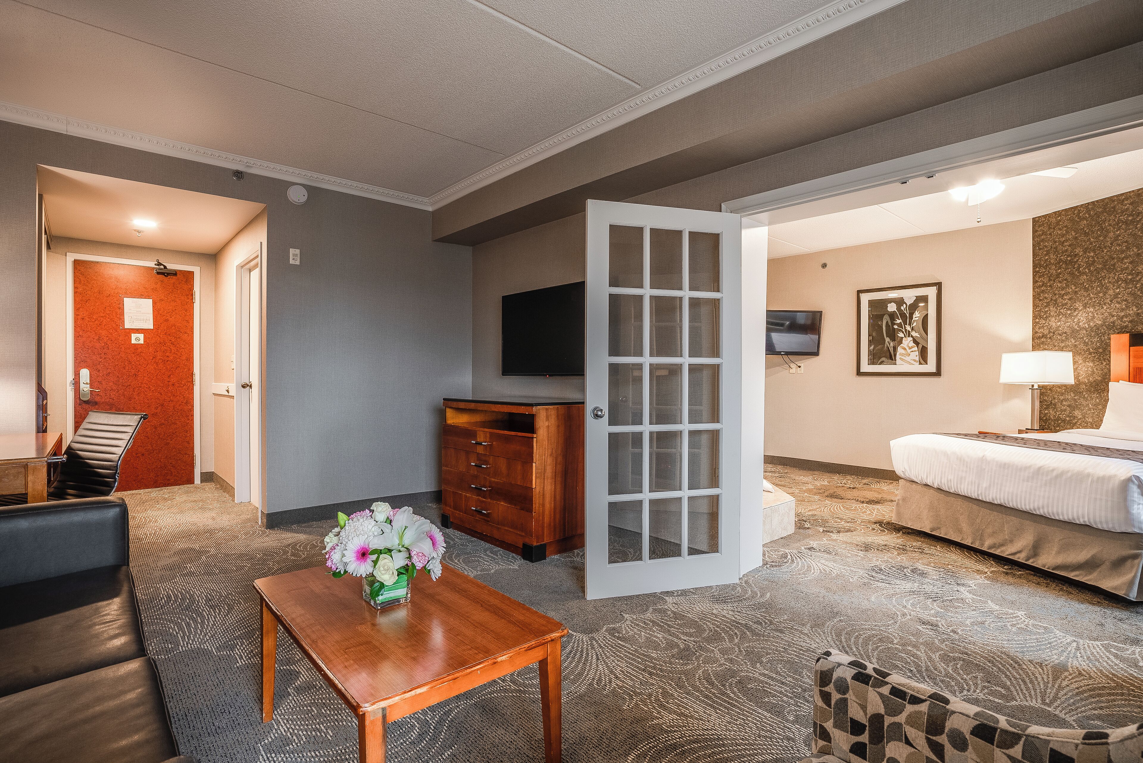 Une chambre d’hôtel avec un lit, une télévision, un bureau et une chaise.