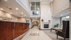 Un hall de hotel con una recepción, una chimenea y un área de estar.