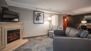 A living room with a fireplace, a television, a patterned rug, and a sofa.