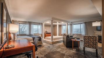 Una habitación de hotel con cama, escritorio, silla y un pequeño rincón de descanso.