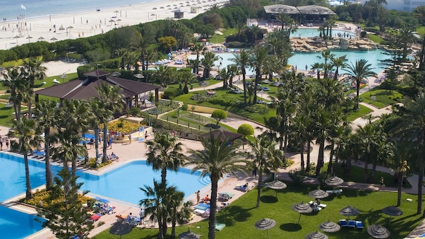 A resort with multiple swimming pools, a beach, and lush landscaping. - Sahara Beach Aquapark (Monastir)