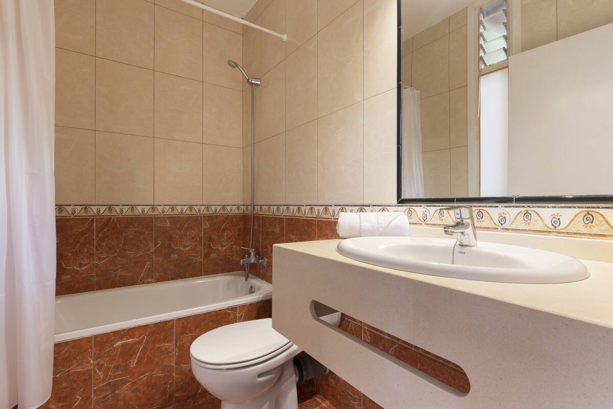 A bathroom with a bathtub, toilet, and sink.
