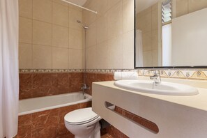 Ein Badezimmer mit Badewanne, Toilette und Waschbecken.